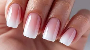 Unhas com efeito ombré suave, com transição delicada de cores claras para o branco