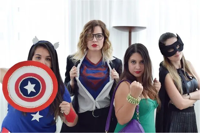 Quatro mulheres fantasiadas de super-heróis de forma criativa e improvisada, prontas para curtir o Carnaval