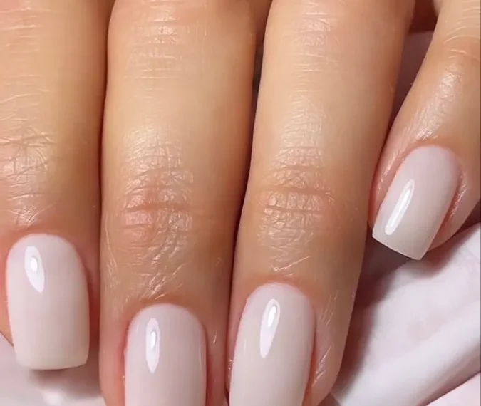 Unhas Milky Nails com acabamento suave e brilho natural, criando um visual clean e elegante