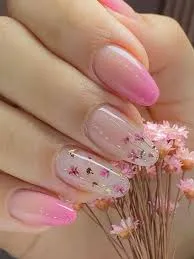 Unhas com flores delicadas em tons de rosa, com acabamento suave e feminino