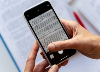 Pessoa usando o scanner do WhatsApp para digitalizar um documento com um smartphone.