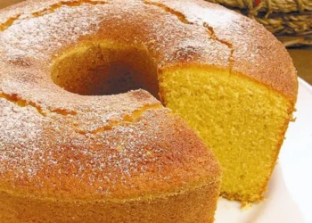 Bolo de fubá fofinho com textura macia e pedaço cortado, ideal para acompanhar café ou chá.