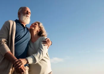 Casal de aposentados caminhando juntos em cenário tranquilo, simbolizando qualidade de vida e tranquilidade na aposentadoria.