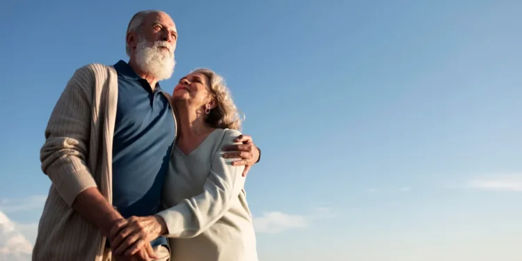 Casal de aposentados caminhando juntos em cenário tranquilo, simbolizando qualidade de vida e tranquilidade na aposentadoria.